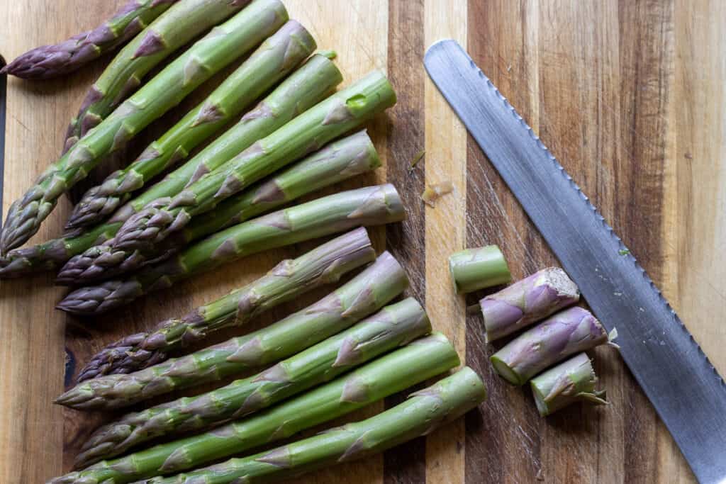 end bits of asparagus are snipped off using a knife