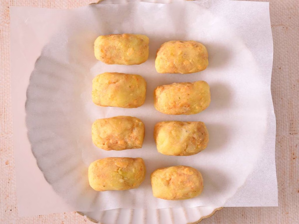 8 pieces of tater tots placed on parchment paper.