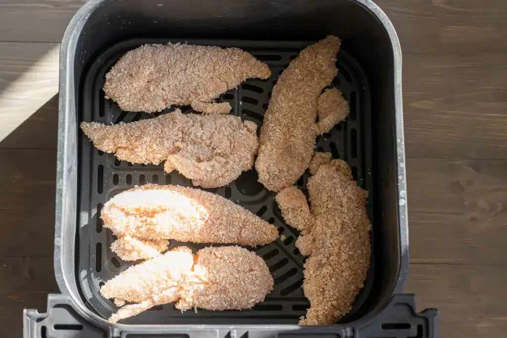 6 pieces of chicken tenders placed in air fryer basket