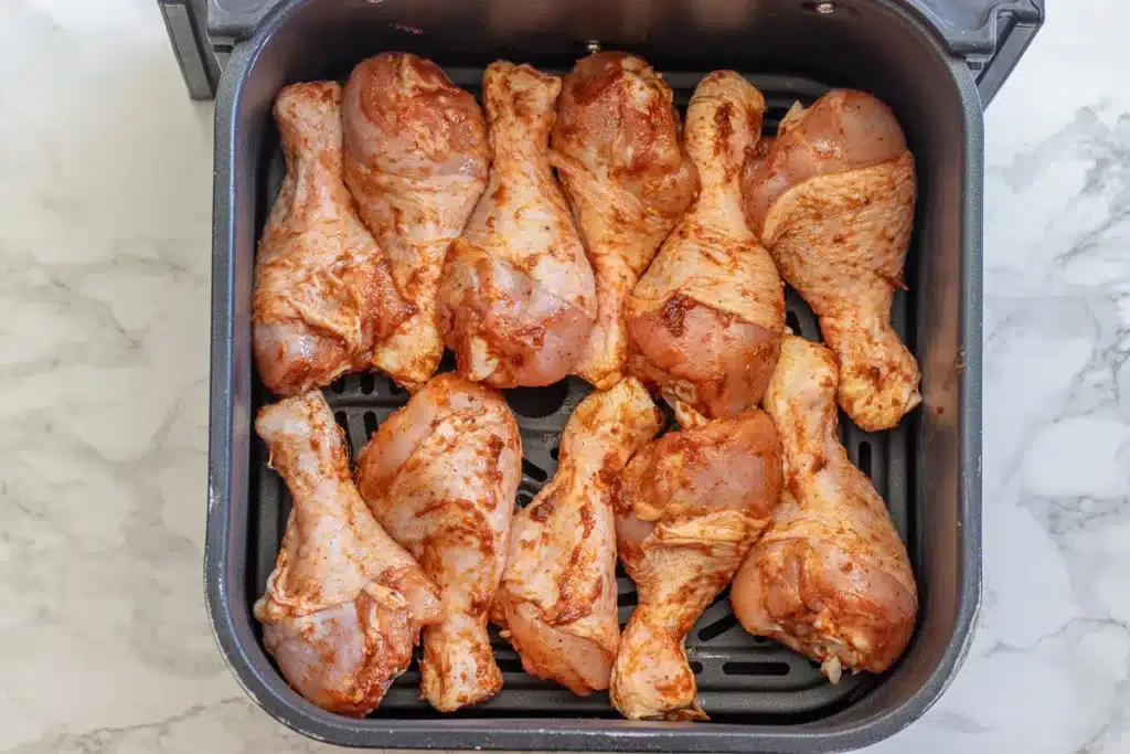 chicken drumsticks are placed in an air fryer