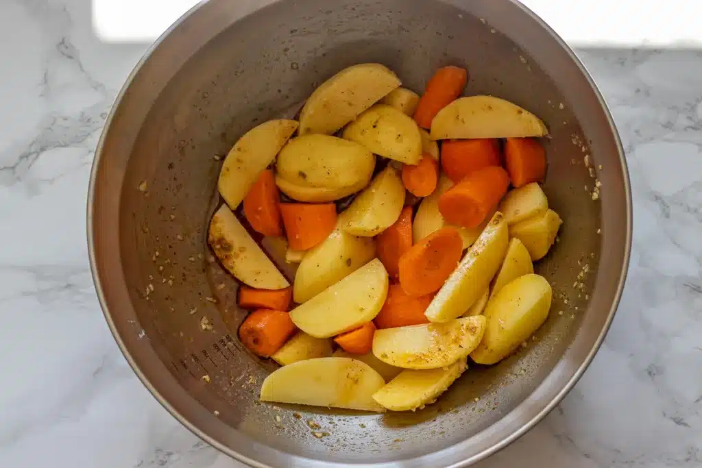 potato and carrot wedges are covered with dressing