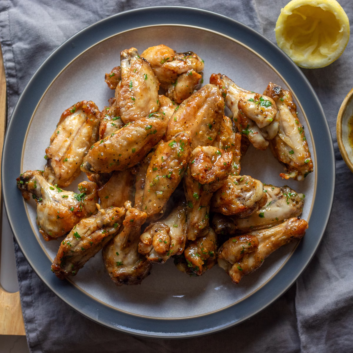 chicken wings glazed with honey lemon pepper sauce and served on a plate